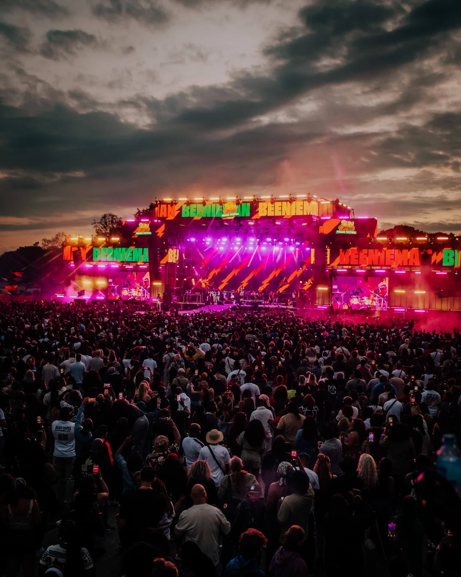 Hoofdpodium van Sun Splash Festival met een volle veld bezoekers bij zonsondergang